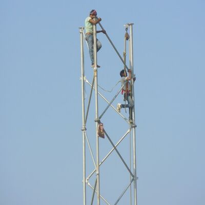 Zelfdragende 3-potige buisvormige stalen toren gegalvaniseerde telecommast geschikt voor buiten 5G 4G magnetroncommunicatie